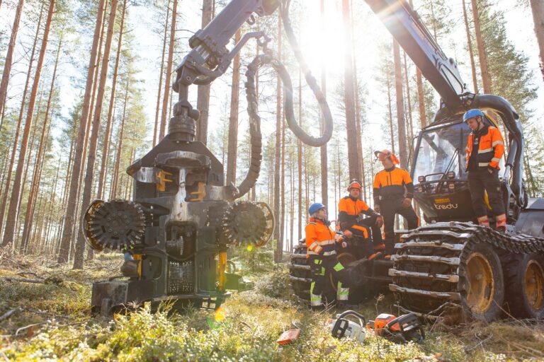 Metsäkone ja metsäammattilaisia metsässä