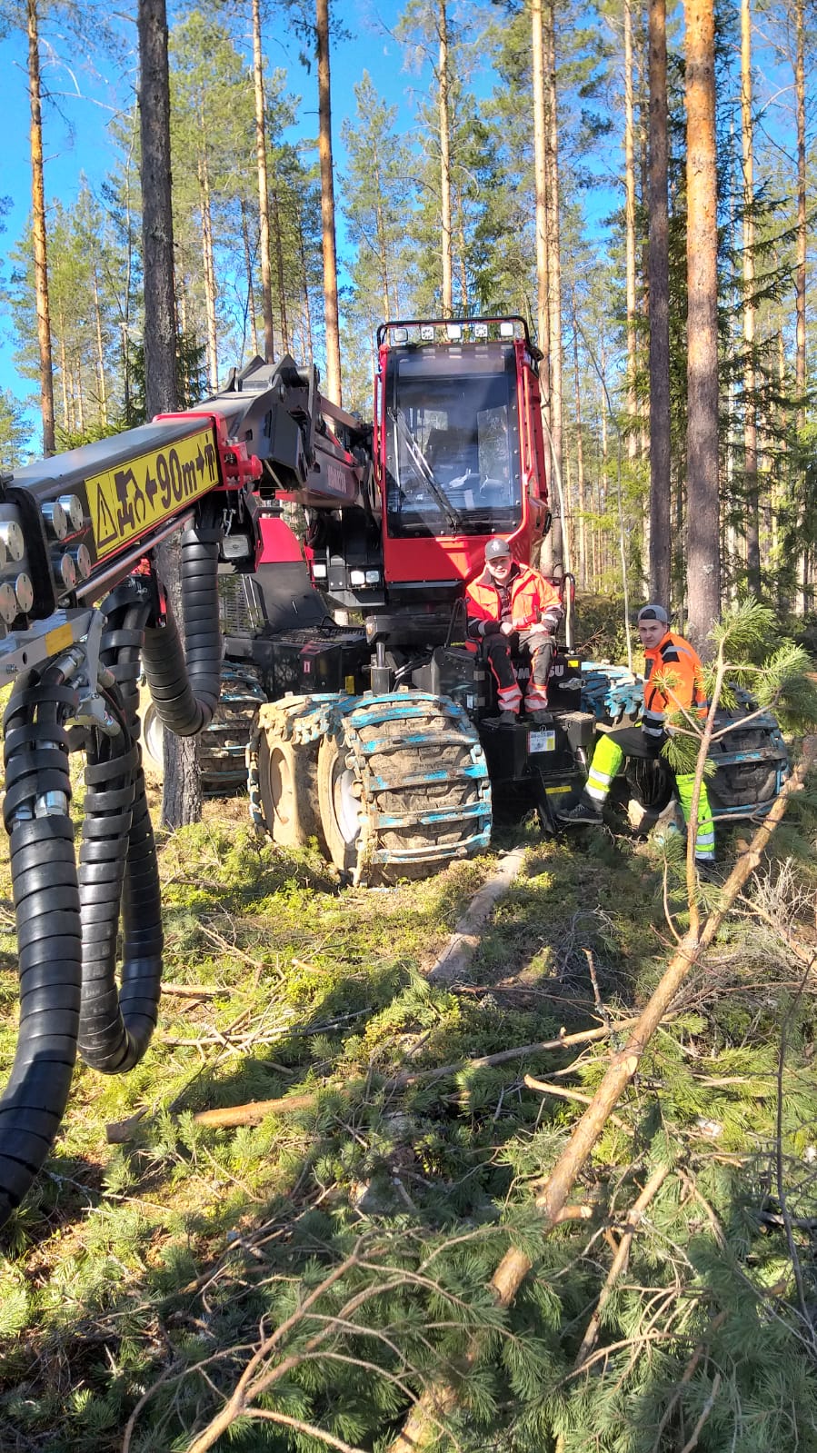 Työkone ja ihmisiä työvaatteissa