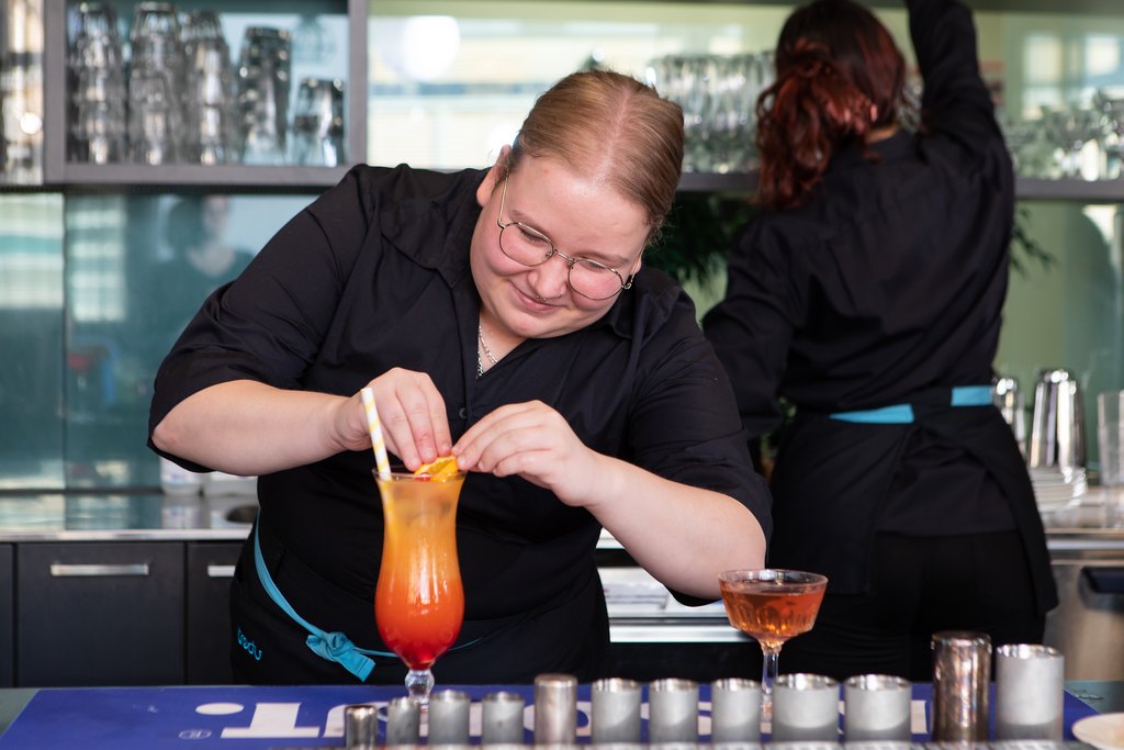 Tredun ravintola-alan opiskelija valmistaa drinkkiä tiskin takana