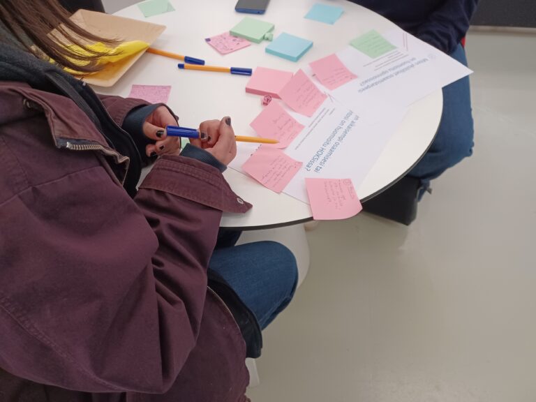 Valkoisella pöydällä eri värisiä post it-lappuja.