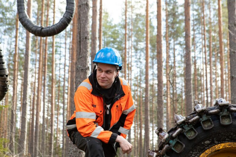 Metsätyömies nojaa metsäkoneeseen