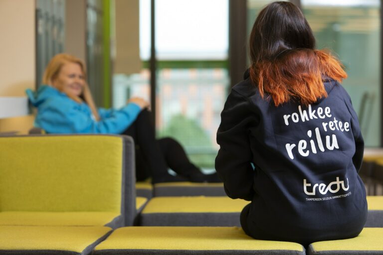 Ihminen Tredu-hupparissa, selässä teksti rohkee, retee, reilu Tredu.