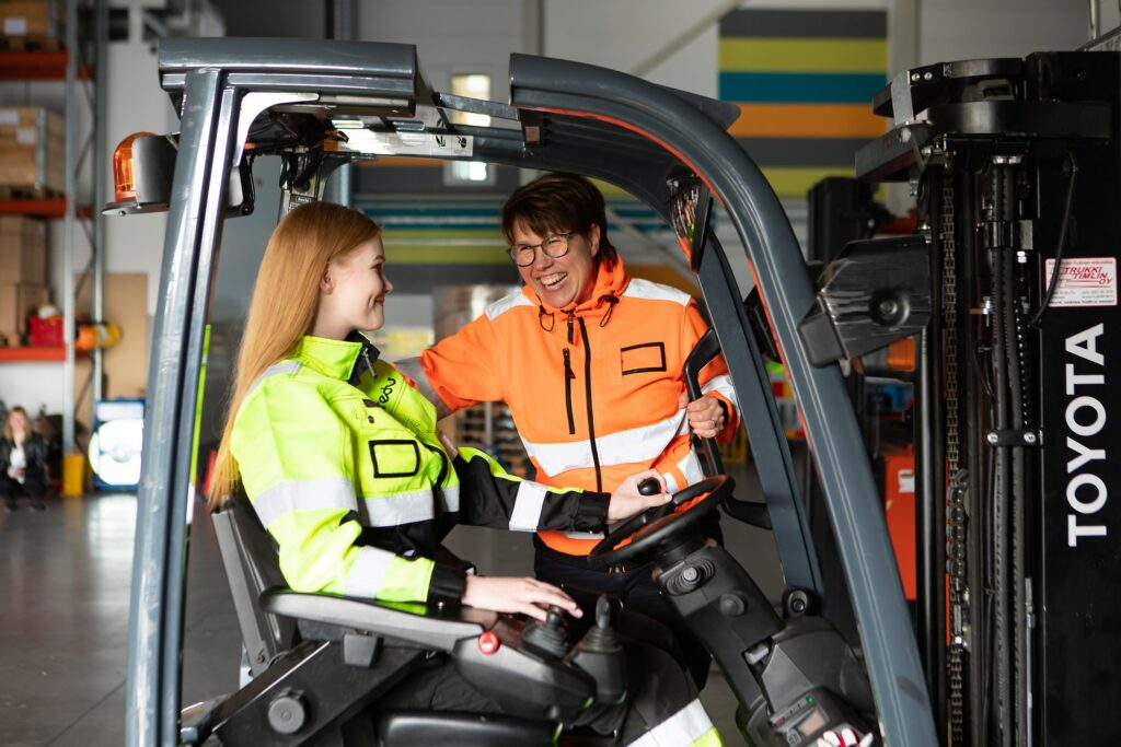 Logistiikka-alan opiskelijoita trukin kyydissä.