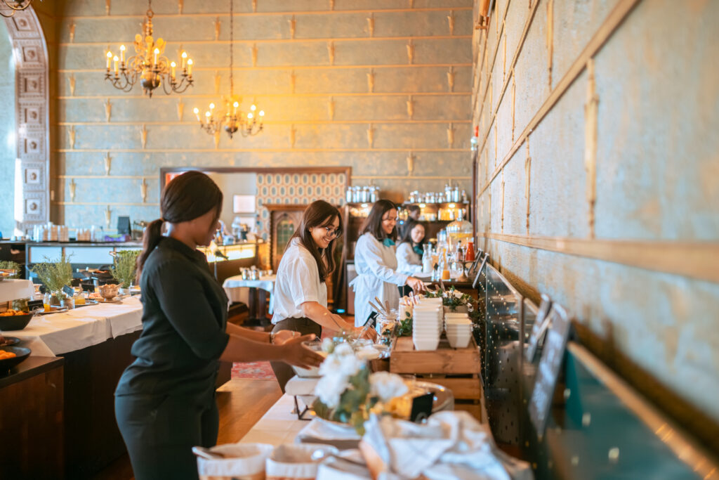 Tredun opiskelijoita järjestelemässä ravintola aamiaispöytää