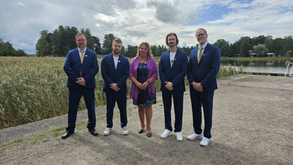 Tredun kilpailijat, ekspertit sekä kilpailupäällikkö katsovat kameraan.
