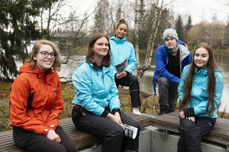 Matkailualan opiskelijoita liikuntavaatteissa ulkona.