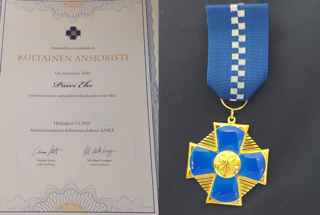 Kunniakirja ja kultainen mitali.